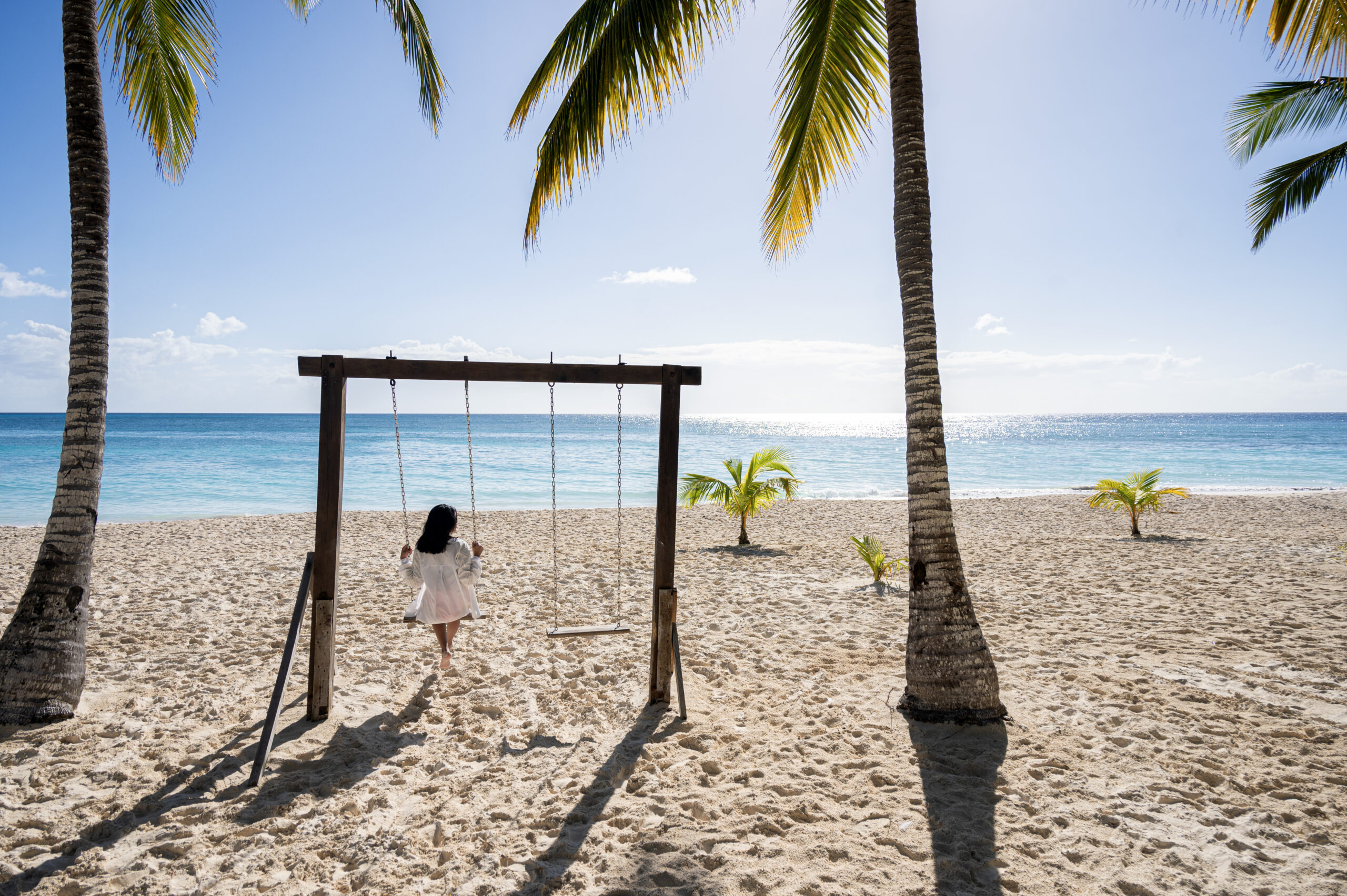Woman sitting on a swing on the beach of the Dominican Republic